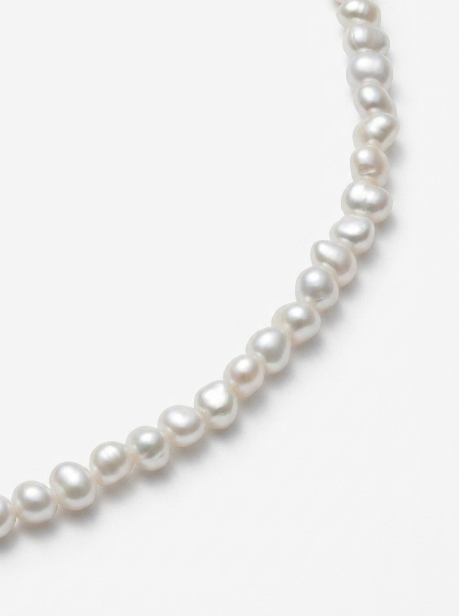 detall de gargantilla amb perles petites desiguals