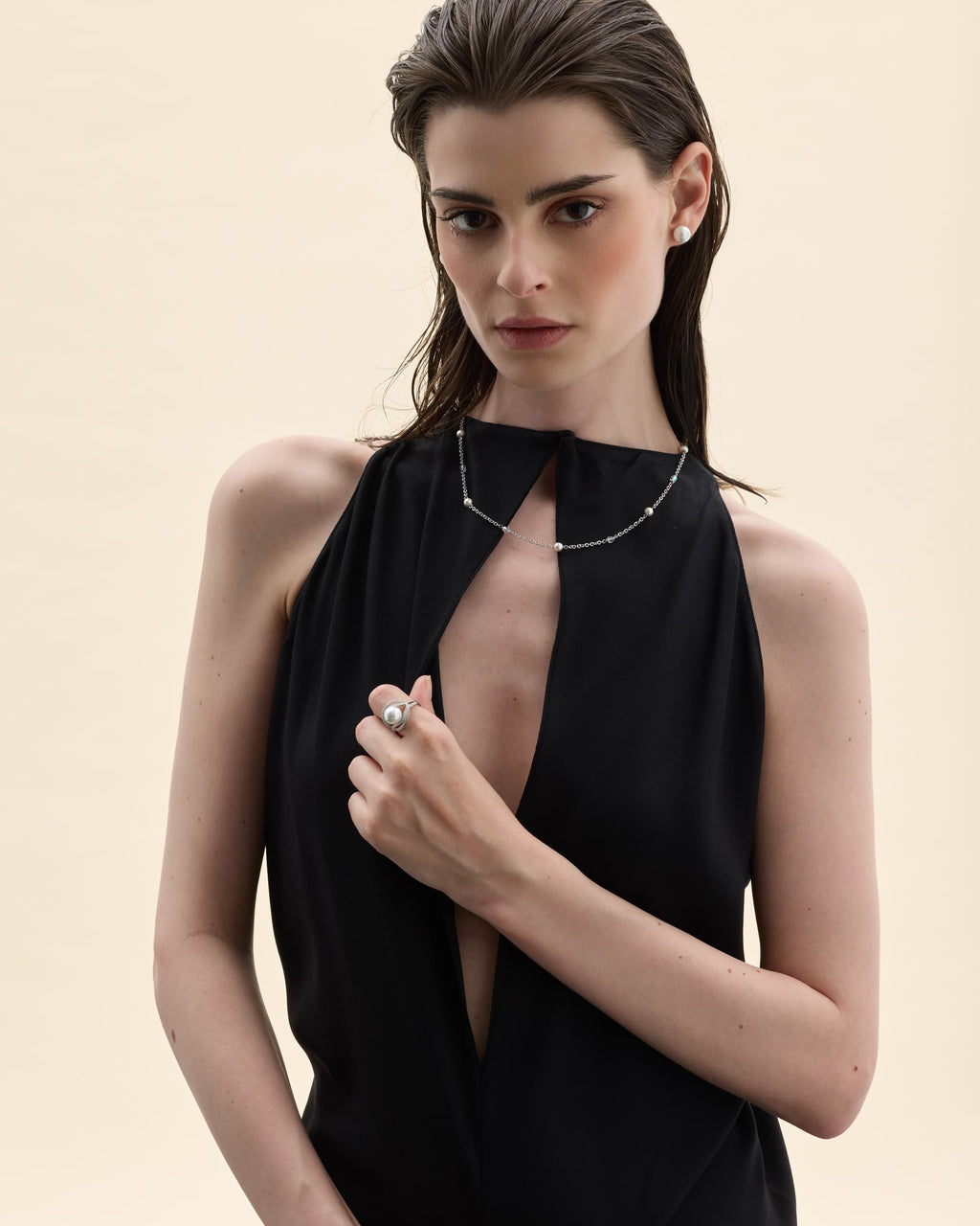 Brunette model in black wearing pearls