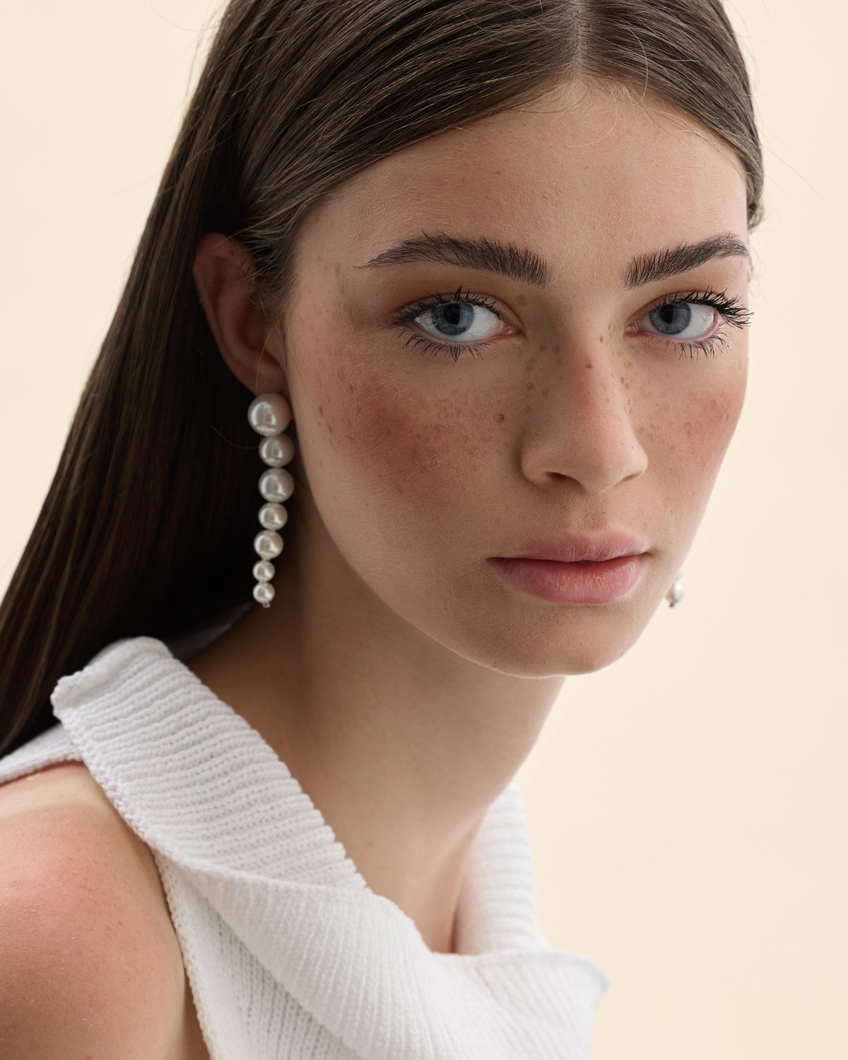 Model mit Perlenohrringen in abnehmender Größe