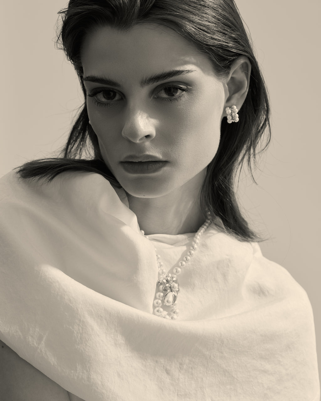 modelo con collar de perlas, y broche de perlas 