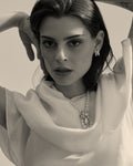 modelo con collar de perlas y broche en forma de flor con perla en forma de lagrima 