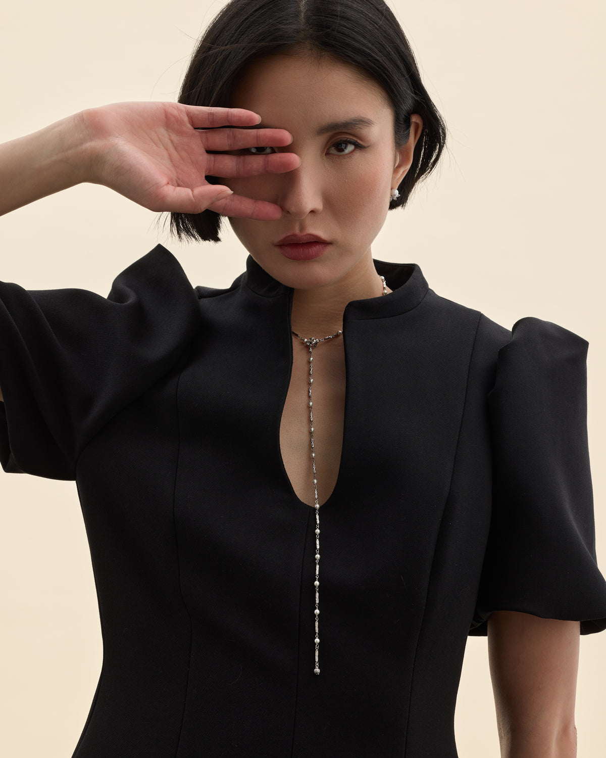 model amb vestit negre i collaret llarg de cadena de plata de llei i mini perles