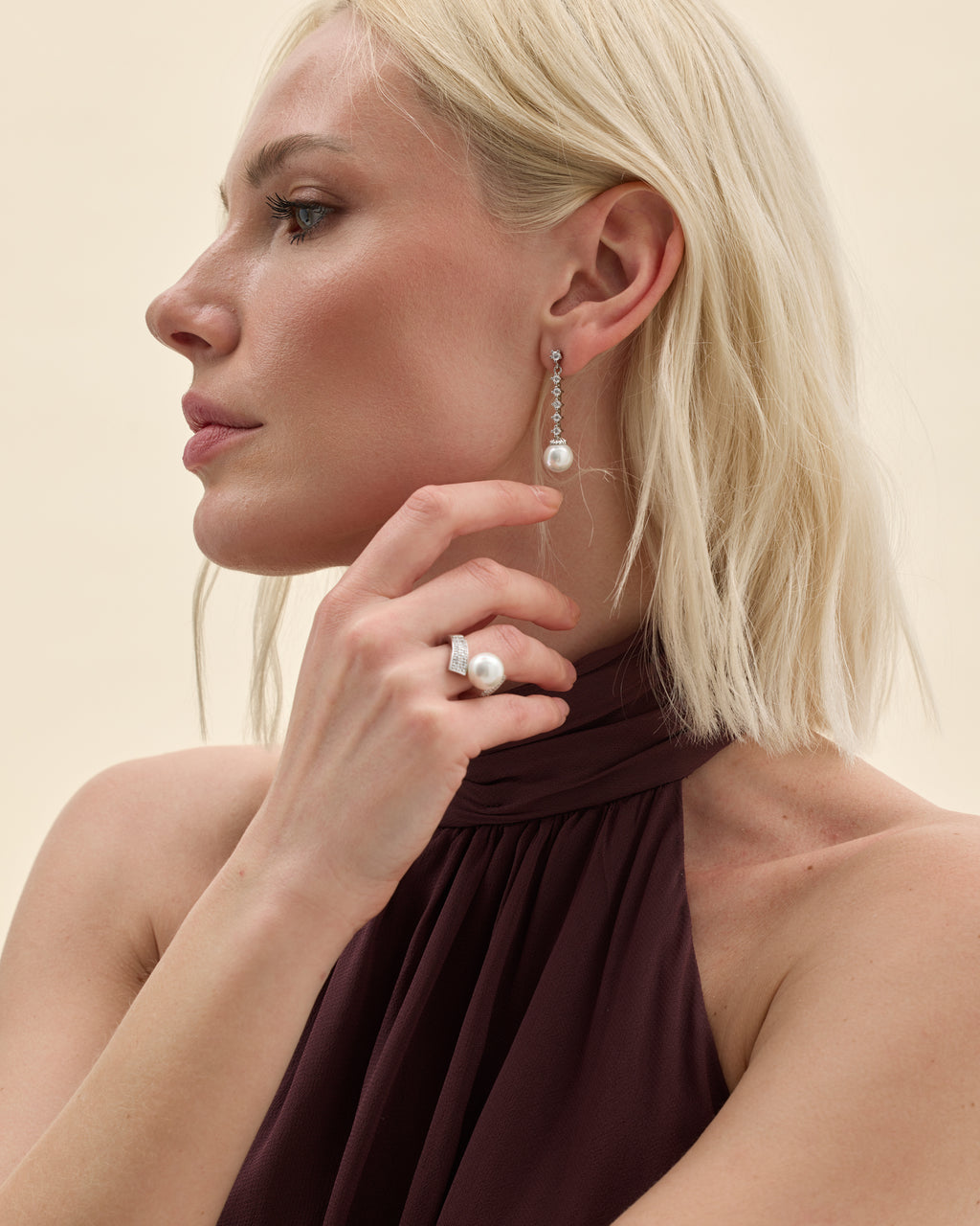Model wearing silver earrings and ring with a white pearl