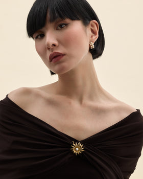Model wearing a pearl brooch on a gold-tone base