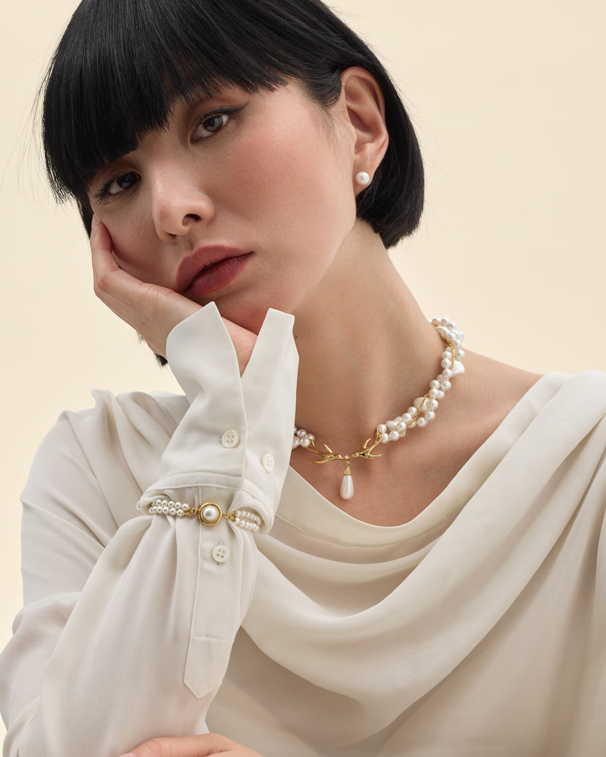 Mannequin portant un collier et un bracelet de perles dorés