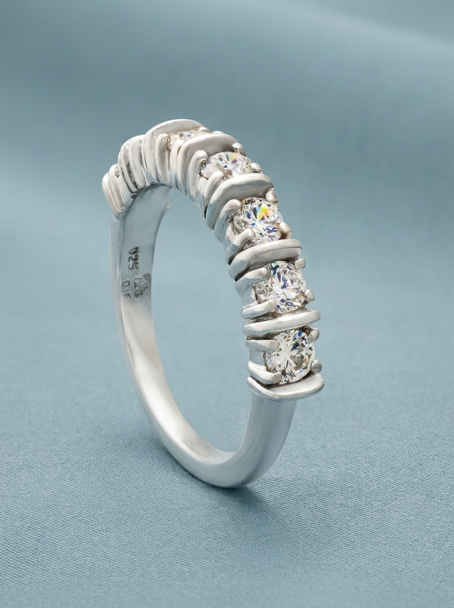foto de anillo sobre fondo azul. Plata de ley con circonitas