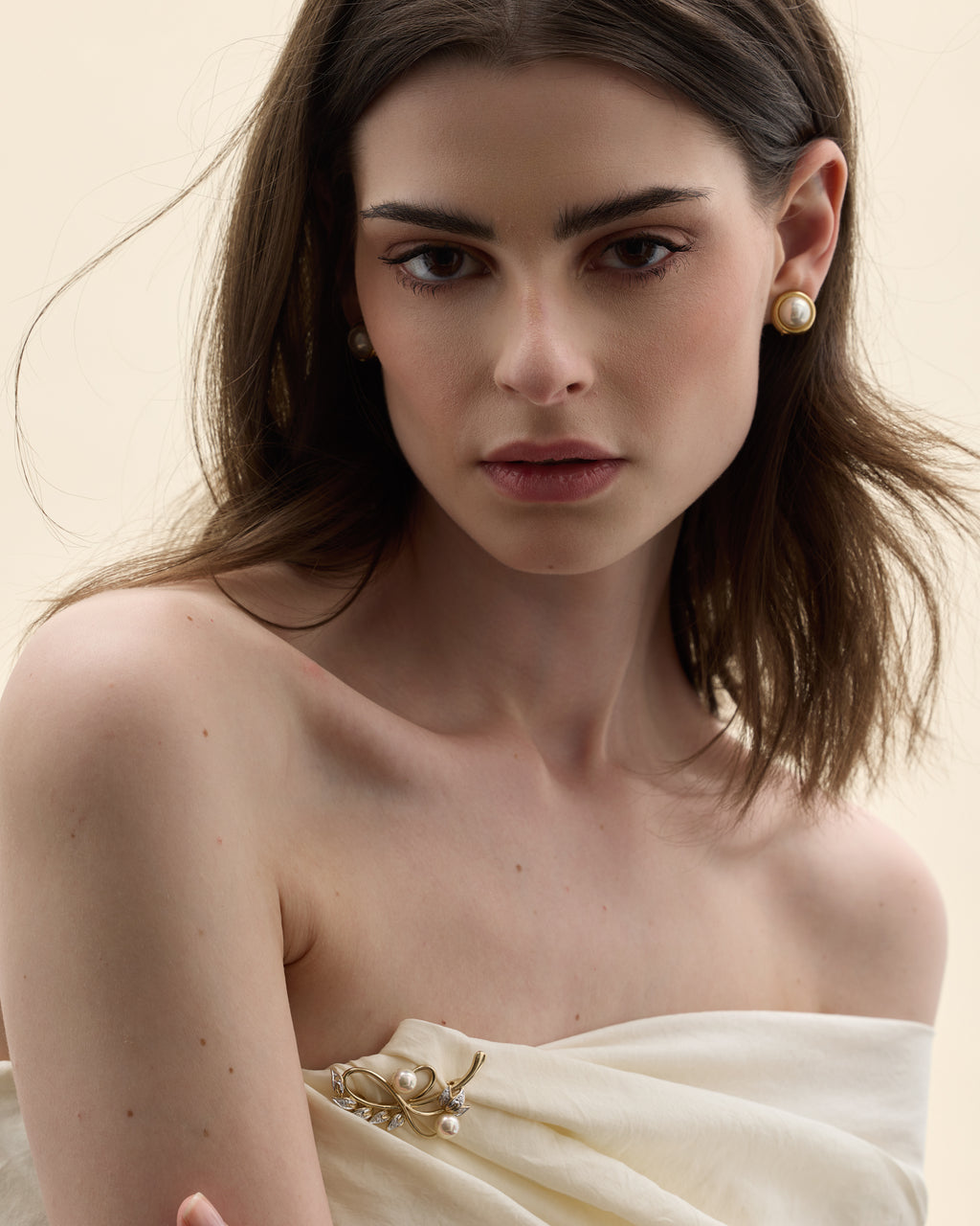 Model wearing an elongated vintage brooch with a Mallorca pearl