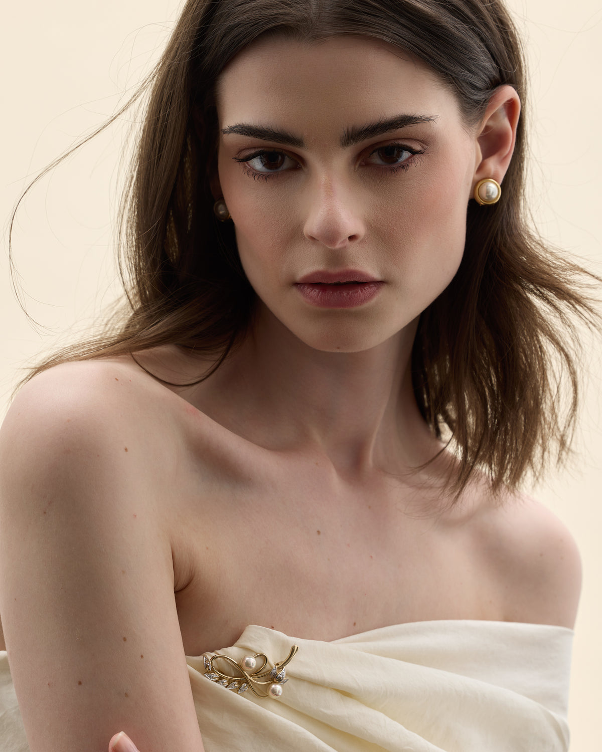 Model wearing an elongated vintage brooch with a Mallorca pearl