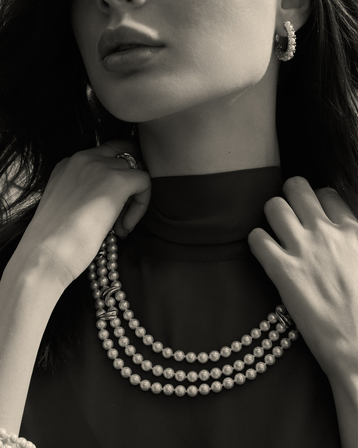 Model wearing a white pearl necklace with gold-tone details
