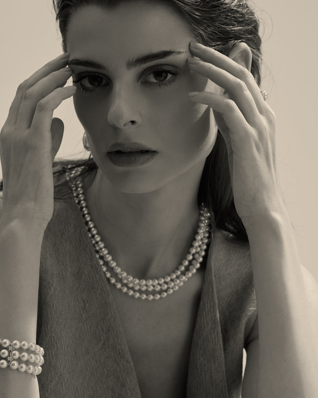 modelo con collar de perlas blancas y cierre dorado 
