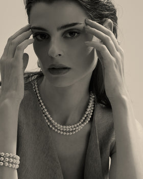 model amb collaret de perles blanques i tancament daurat 