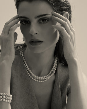 modelo con collar de perlas blancas y cierre dorado 
