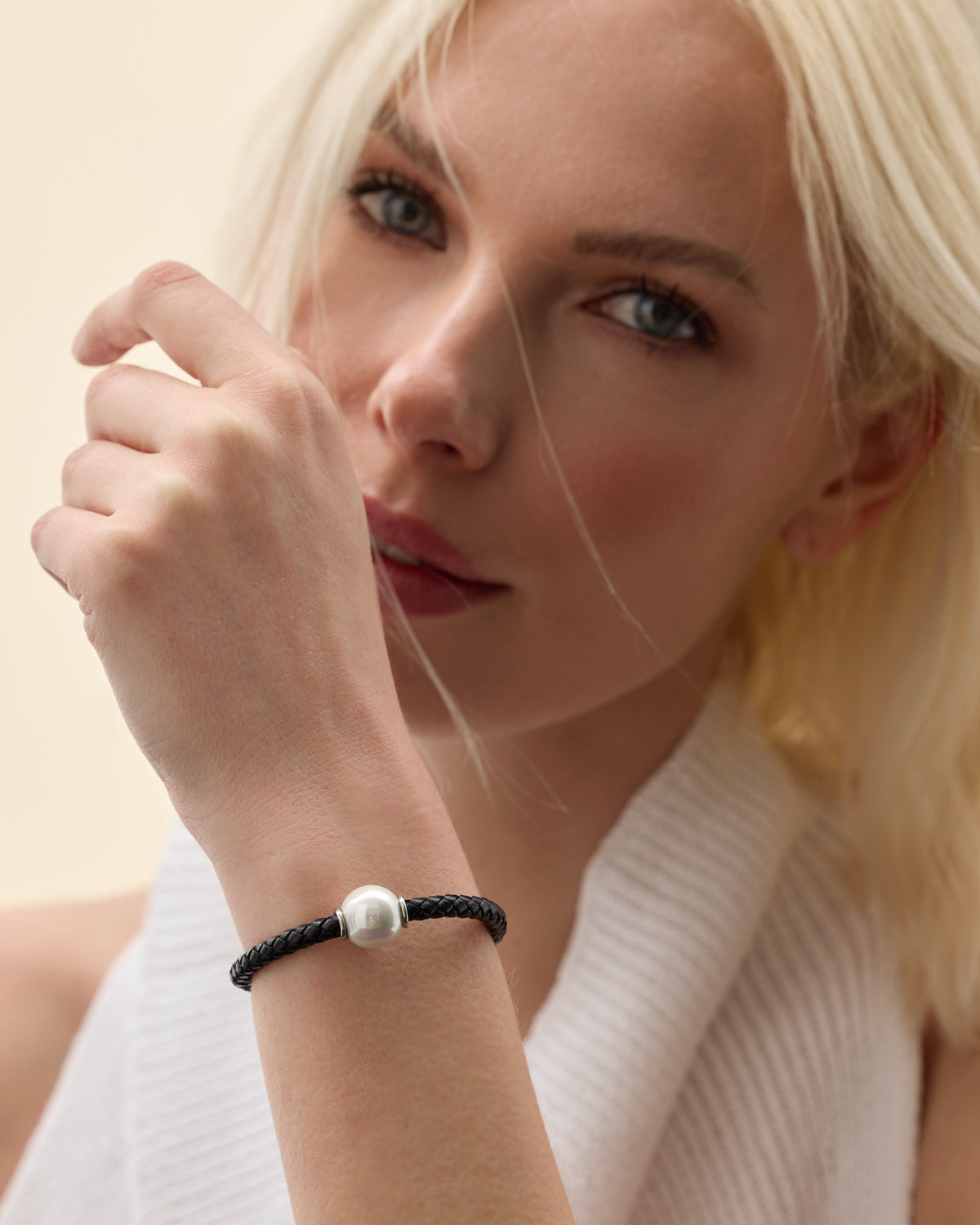 Model wearing a black leather and pearl bracelet