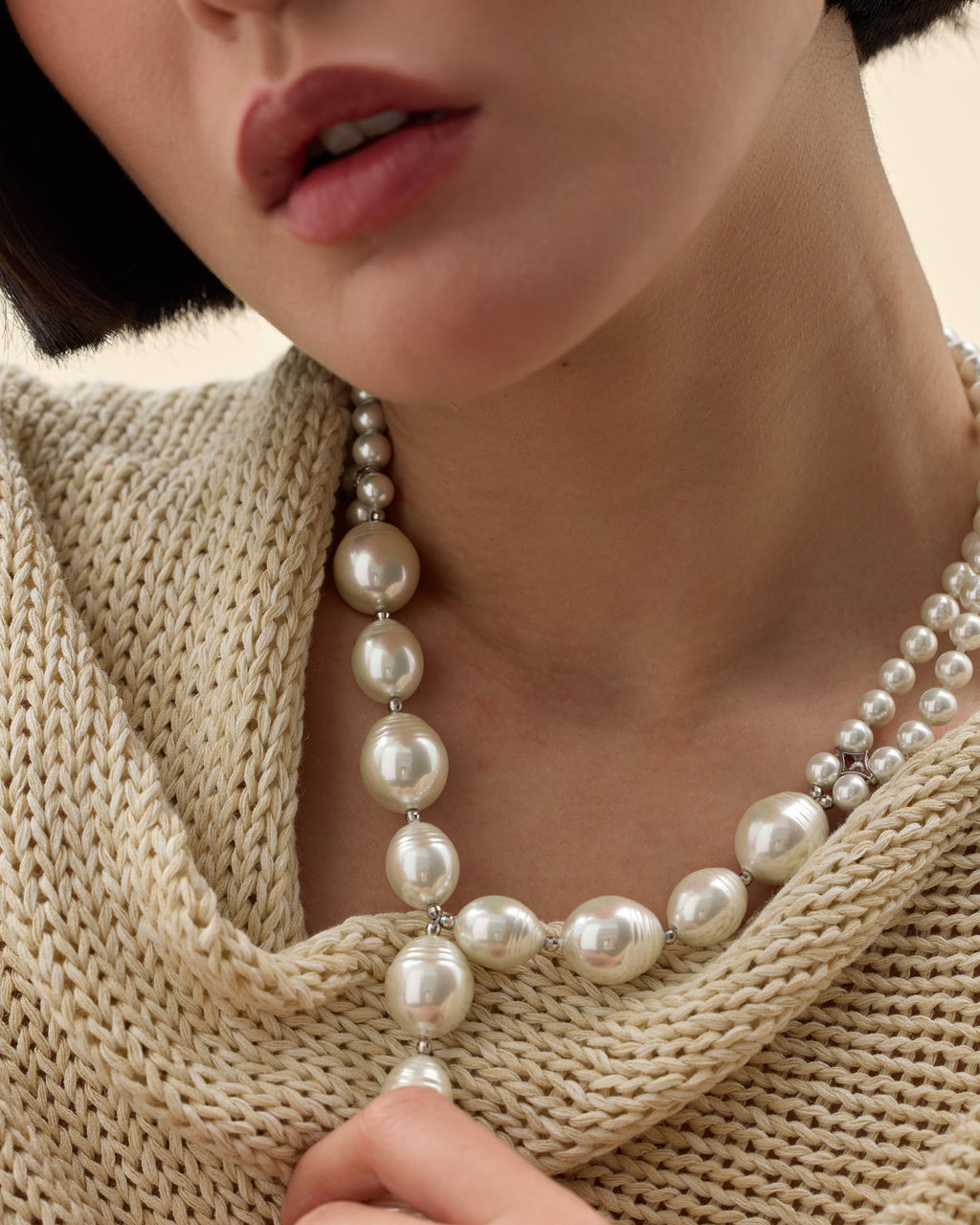 modelo con collar de perlas grande y plata 