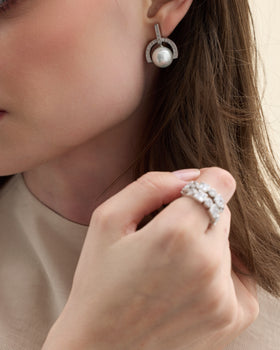 Model wearing silver earrings with cubic zirconia and a Mallorca pearl