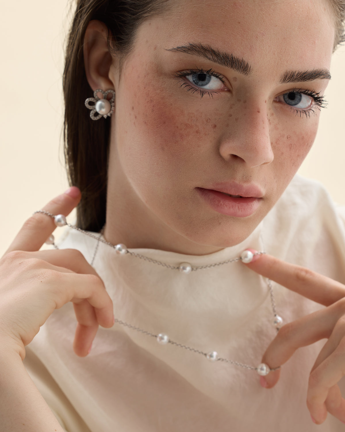 detalle de pendientes con modelo de perla y circonita