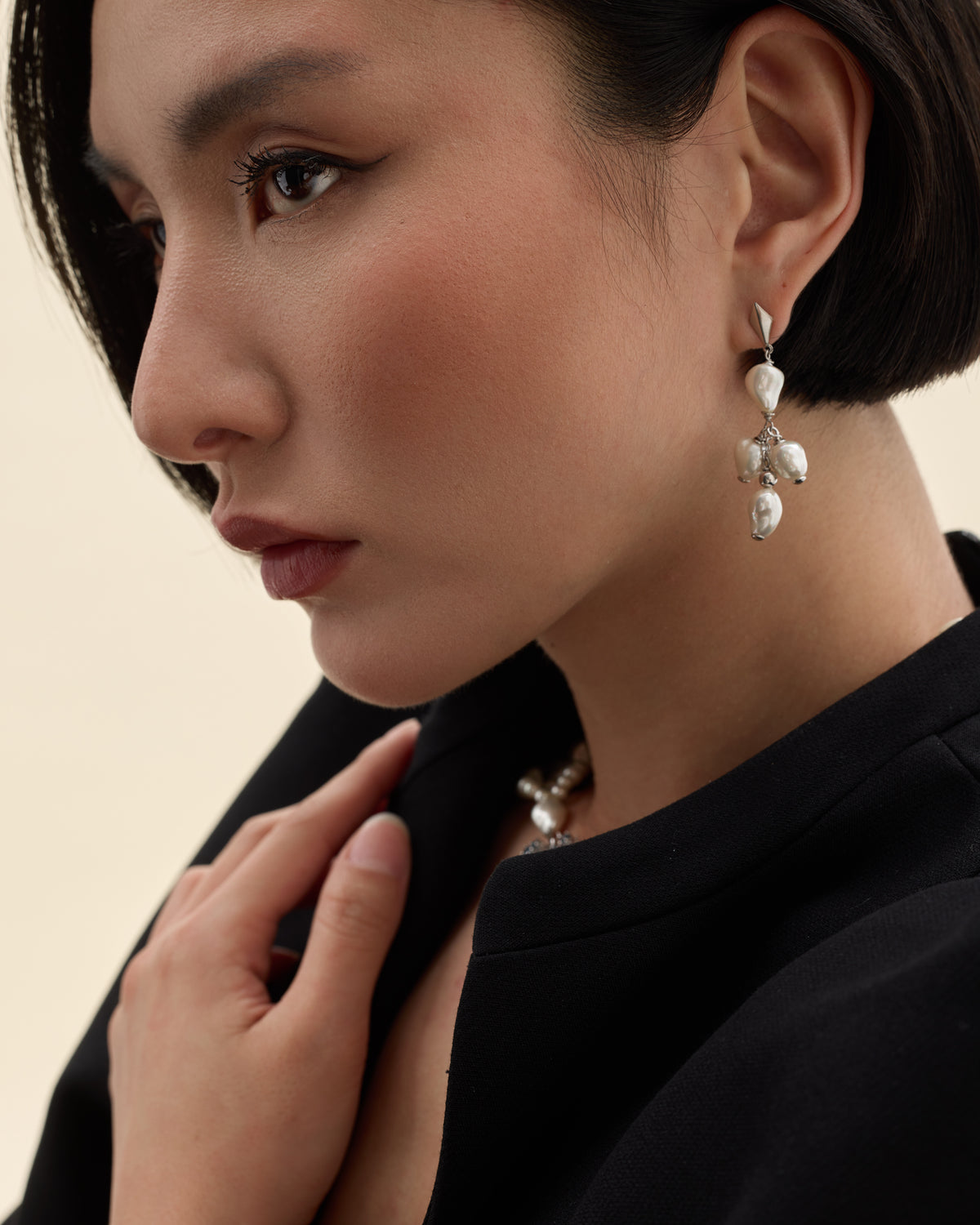 Model wearing geometric silver earrings with a Mallorca baroque pearl