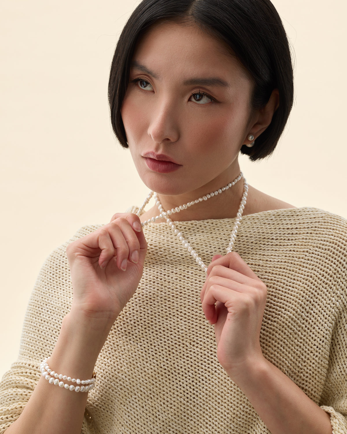 modelo con collar de perlas blancas diferentes tamaños de perlas 