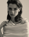Model wearing a pearl brooch with matching earrings and ring