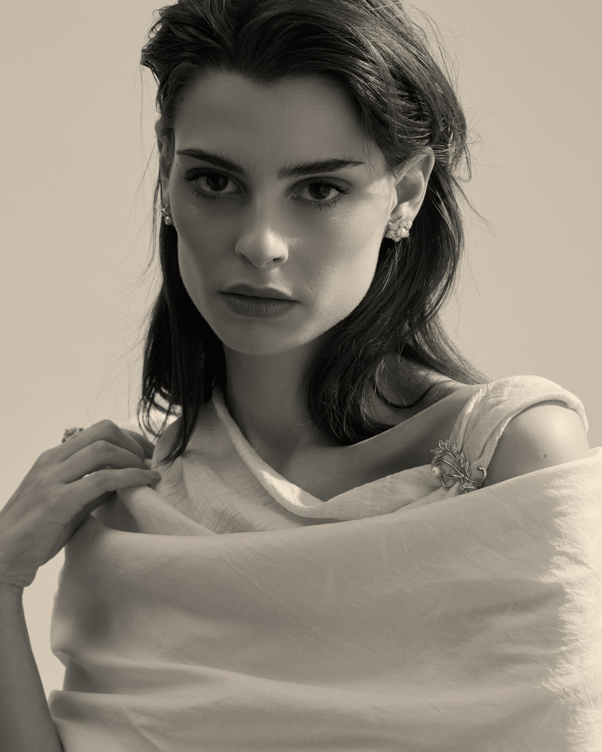 Model wearing a pearl brooch with matching earrings and ring