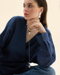 Model wearing a long black and white pearl necklace